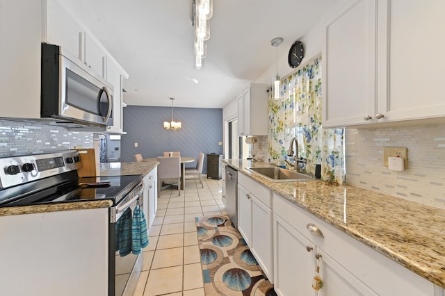 kitchen with pendant lighting, white cabinets, light tile patterned floors, and appliances with stainless steel finishes