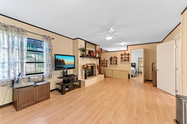 living room with ceiling fan, light hardwood / wood-style floors, and ornamental molding