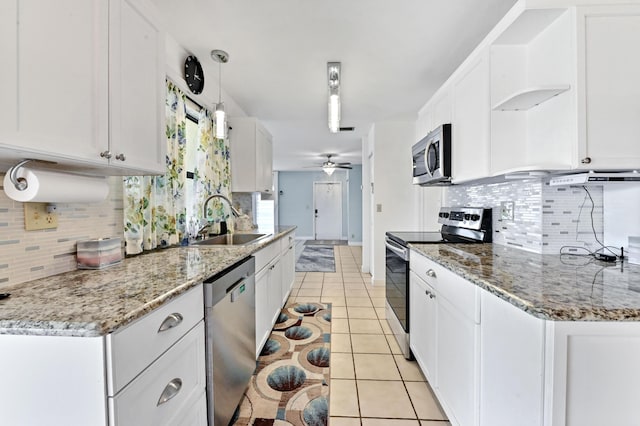 kitchen featuring a sink, appliances with stainless steel finishes, white cabinets, and light tile patterned floors