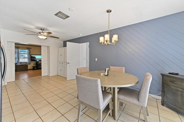 dining space featuring light tile patterned floors and ceiling fan with notable chandelier