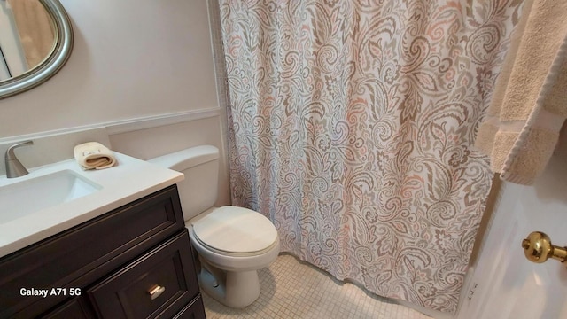 bathroom with tile patterned flooring, vanity, and toilet