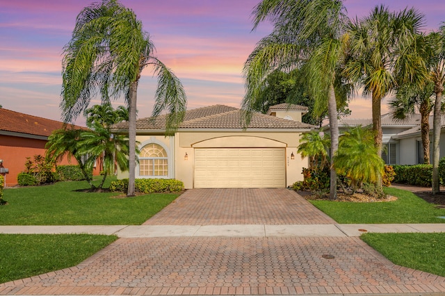 mediterranean / spanish-style house with a yard and a garage