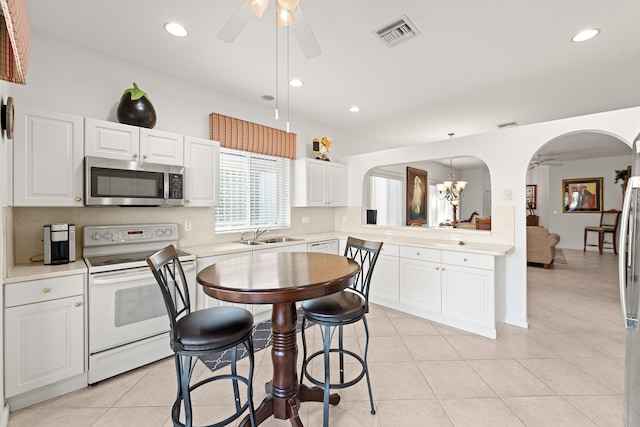 kitchen with white cabinetry, light tile patterned floors, white electric range, decorative light fixtures, and ceiling fan with notable chandelier