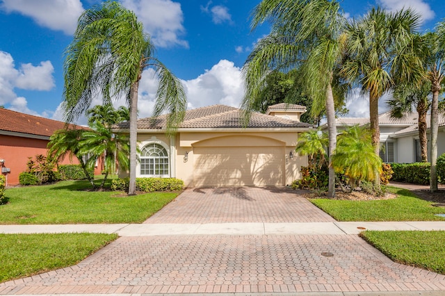 mediterranean / spanish house featuring a front yard and a garage