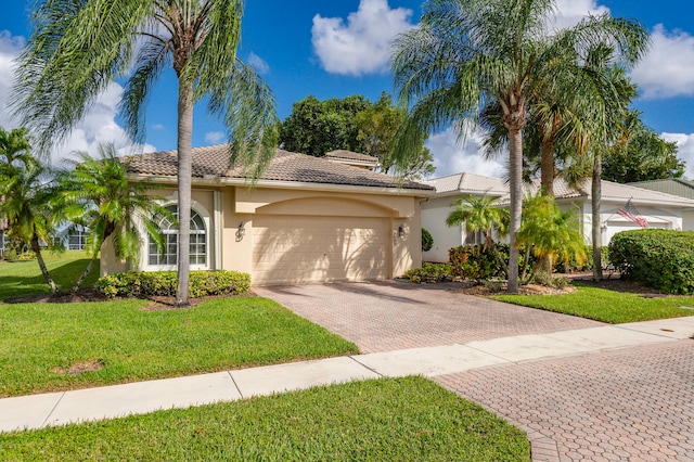 mediterranean / spanish-style home with a front yard and a garage