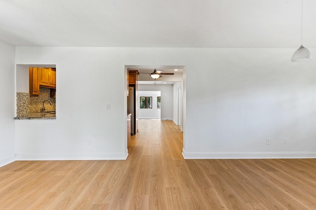 spare room with ceiling fan, sink, and light hardwood / wood-style floors