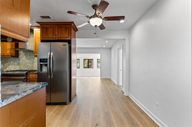 kitchen featuring backsplash, stainless steel appliances, ceiling fan, light hardwood / wood-style flooring, and stone counters