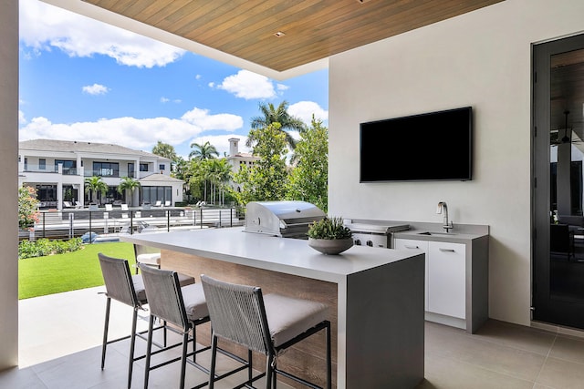 view of patio with a grill, an outdoor wet bar, and exterior kitchen