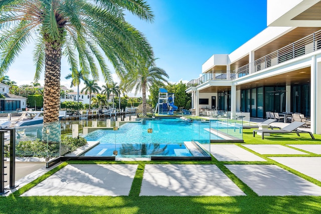 view of swimming pool featuring a water view and a patio