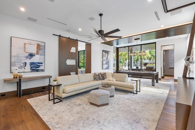 living room with hardwood / wood-style floors, a barn door, plenty of natural light, and ceiling fan