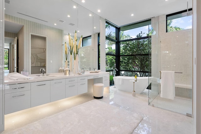 bathroom with a tub to relax in, floor to ceiling windows, a wealth of natural light, and vanity