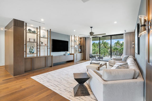 living room featuring floor to ceiling windows, ceiling fan, and light hardwood / wood-style floors