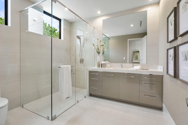 bathroom featuring toilet, vanity, and walk in shower