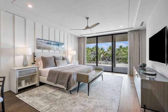 bedroom featuring hardwood / wood-style floors, ceiling fan, expansive windows, and access to exterior