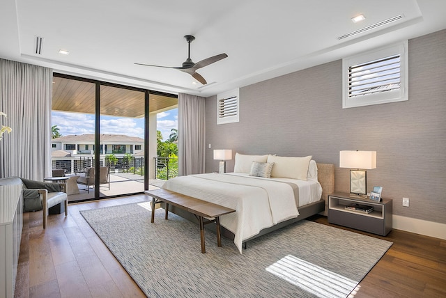 bedroom featuring access to outside, ceiling fan, dark hardwood / wood-style flooring, and expansive windows