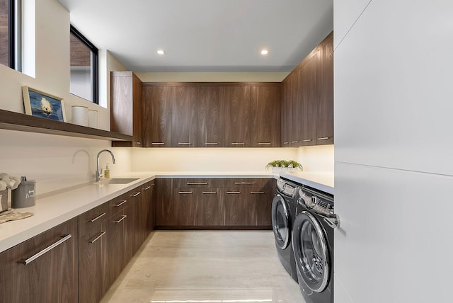 washroom with cabinets, sink, and washing machine and clothes dryer