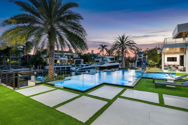 view of pool featuring a lawn and a patio