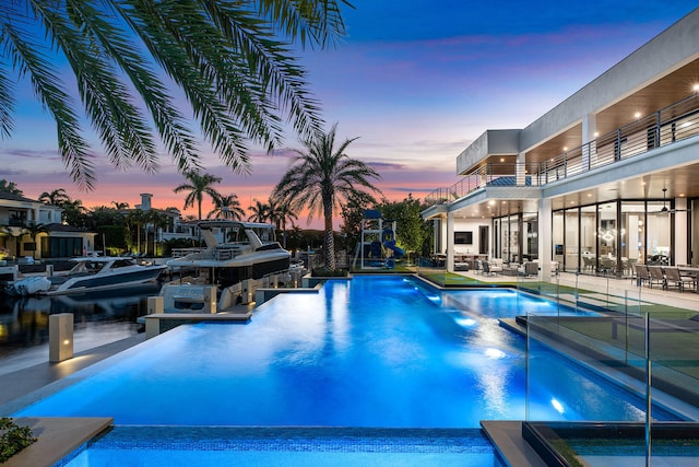 pool at dusk with a patio