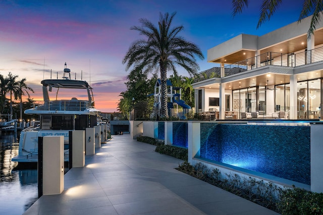 pool at dusk featuring a patio area