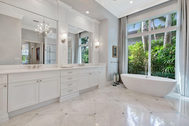 bathroom featuring a chandelier, ornamental molding, vanity, and a tub