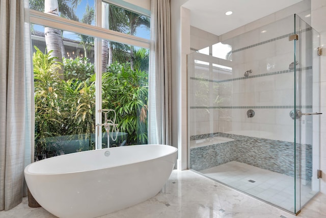 bathroom with separate shower and tub and plenty of natural light