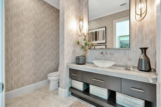 bathroom featuring tile patterned floors, crown molding, vanity, and toilet