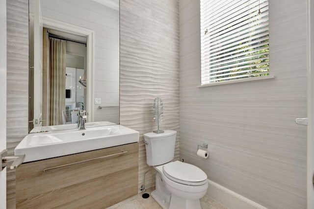 bathroom featuring tile patterned flooring, vanity, and toilet