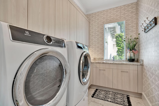 washroom with cabinets, crown molding, independent washer and dryer, and sink