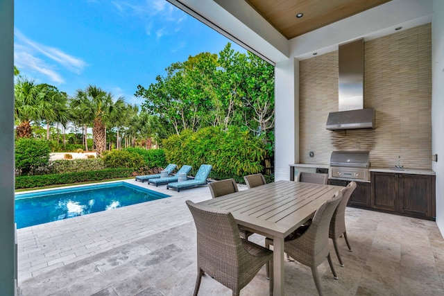 view of swimming pool with area for grilling, sink, exterior kitchen, and a patio