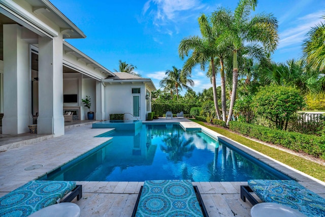 view of swimming pool featuring an outdoor fireplace and a patio