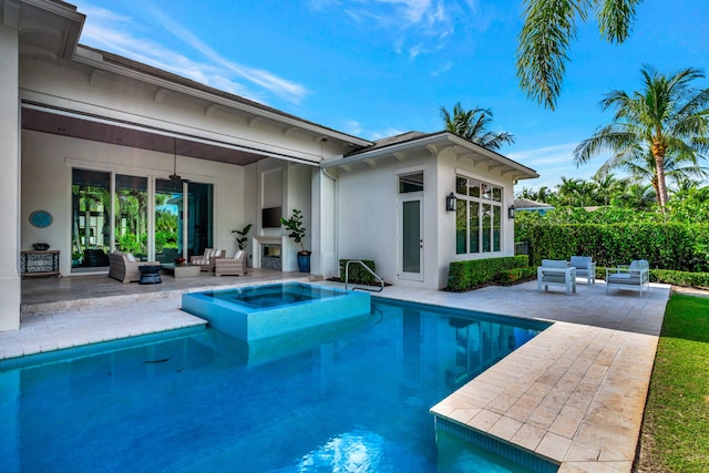 back of house with a swimming pool with hot tub, an outdoor hangout area, and a patio