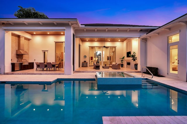 view of swimming pool with outdoor lounge area, exterior kitchen, and a patio