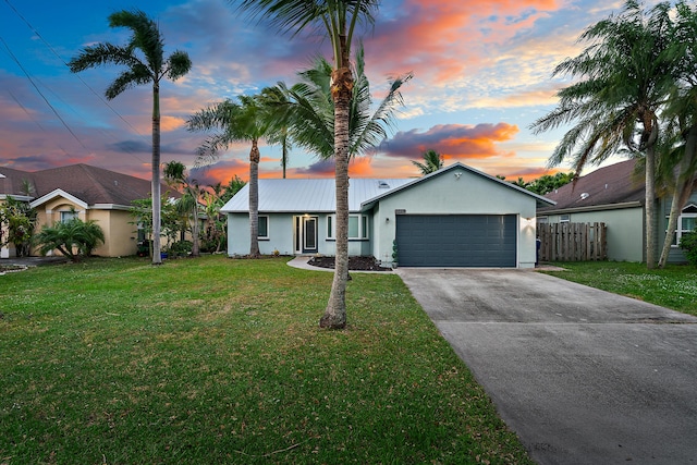 single story home featuring a lawn and a garage