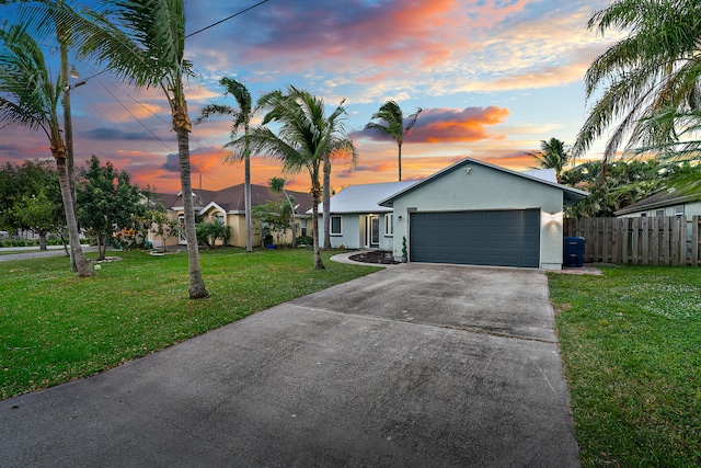 ranch-style house with a garage and a yard