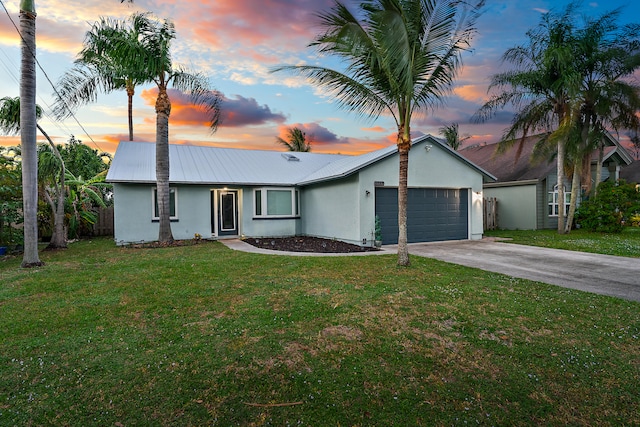 single story home with a lawn and a garage