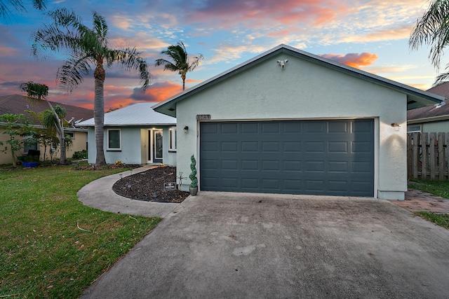 single story home with a garage and a lawn