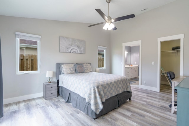 bedroom featuring ensuite bathroom, vaulted ceiling, ceiling fan, a spacious closet, and a closet