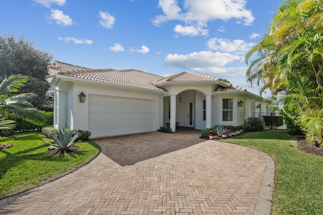 mediterranean / spanish home with a front lawn and a garage