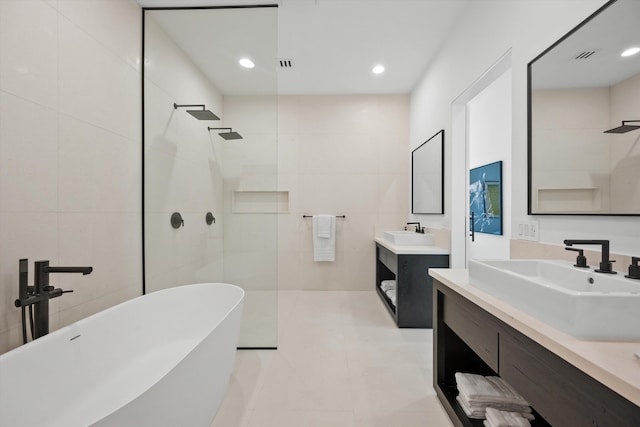 bathroom featuring tile patterned flooring, shower with separate bathtub, vanity, and tile walls