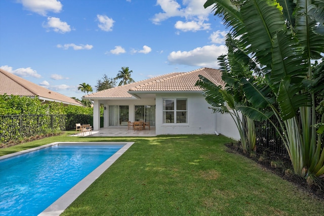 back of house featuring a yard, a patio, and a fenced in pool