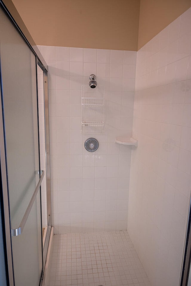 bathroom featuring tile patterned floors and a tile shower