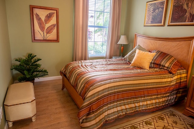 bedroom with baseboards and wood finished floors