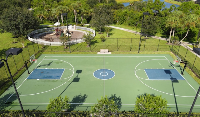 view of basketball court with a yard, fence, and community basketball court