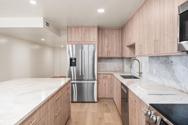 kitchen featuring sink, light hardwood / wood-style flooring, stainless steel appliances, and light brown cabinets