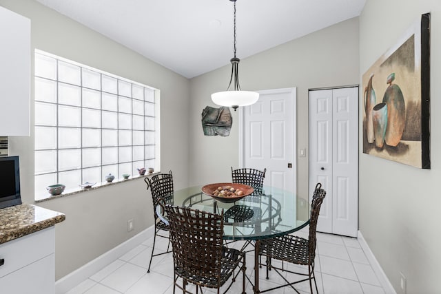 dining space featuring lofted ceiling and light tile patterned floors