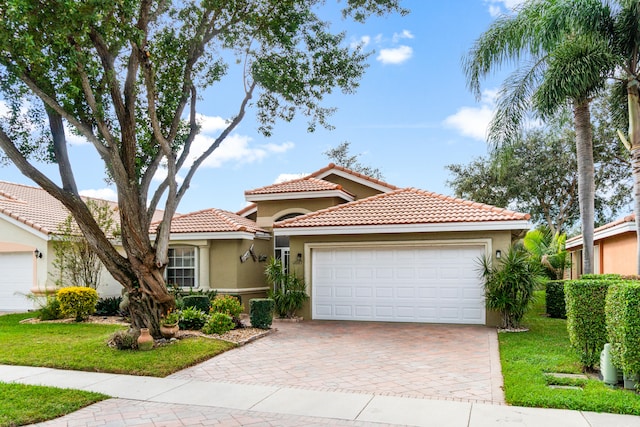 mediterranean / spanish home with a front yard and a garage