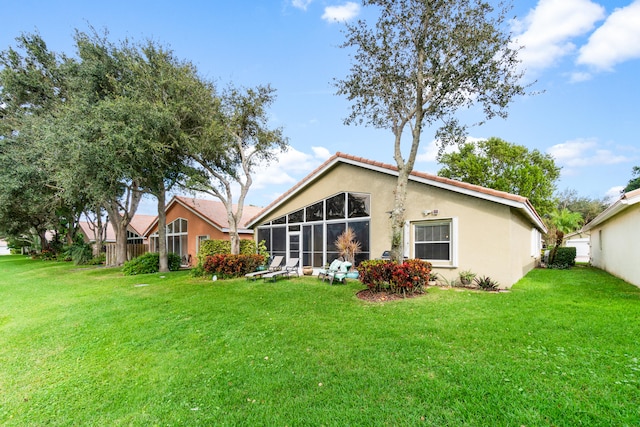 back of property featuring a yard and a sunroom