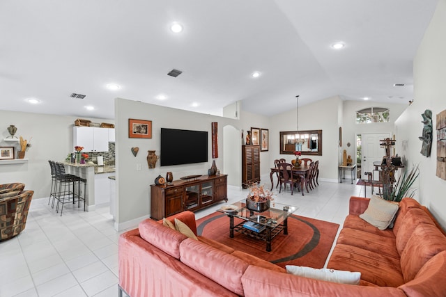 living room featuring light tile patterned floors, vaulted ceiling, and an inviting chandelier