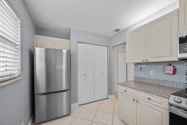 kitchen with light tile patterned floors and stainless steel appliances