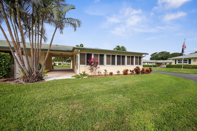 single story home with a front lawn and a carport